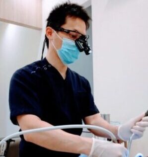 拡大鏡を使って治療をする歯科医師